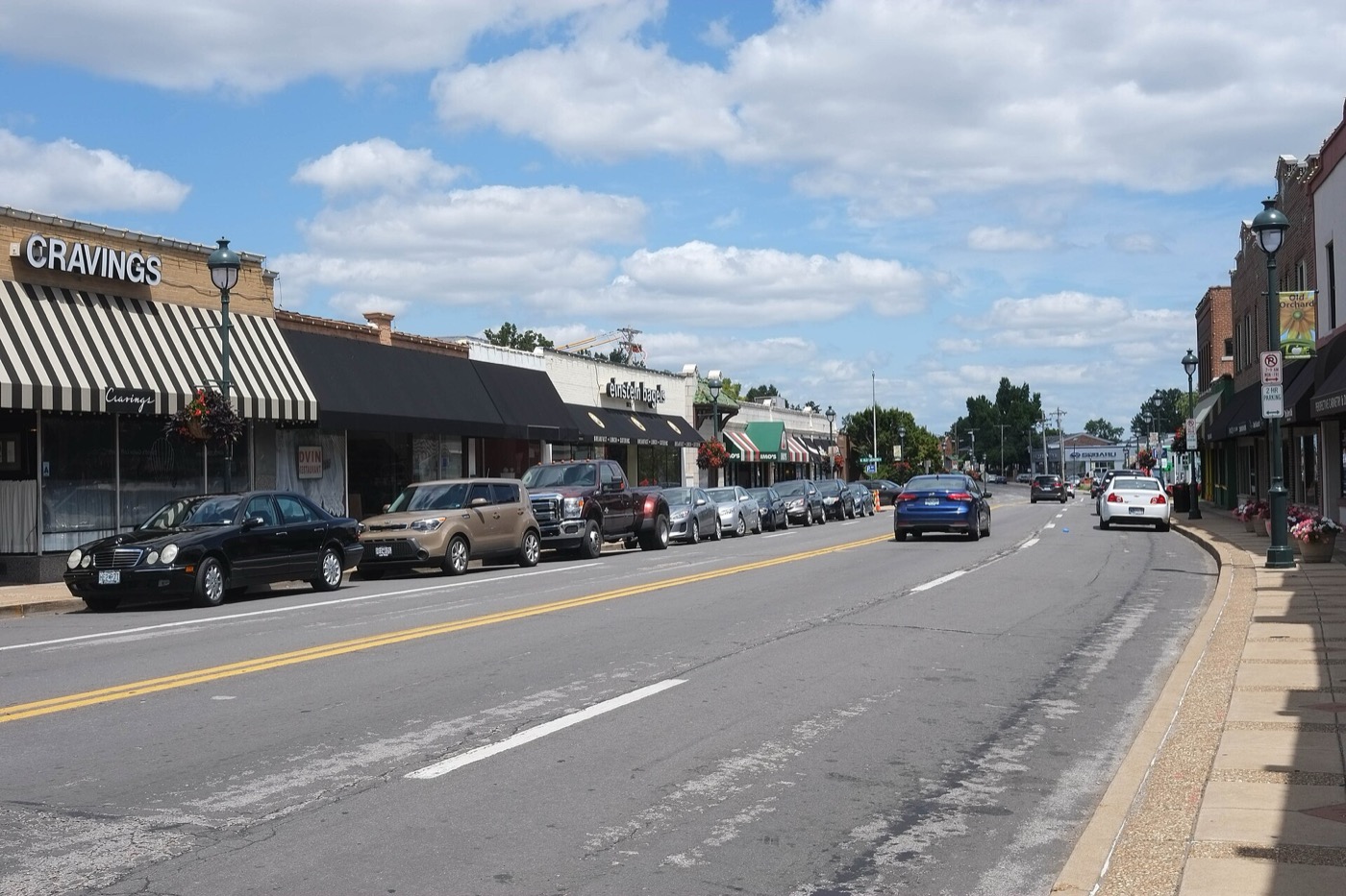 Storefronts with awnings and parked cars along Big Bend Boulevard in Webster Groves, Missouri
