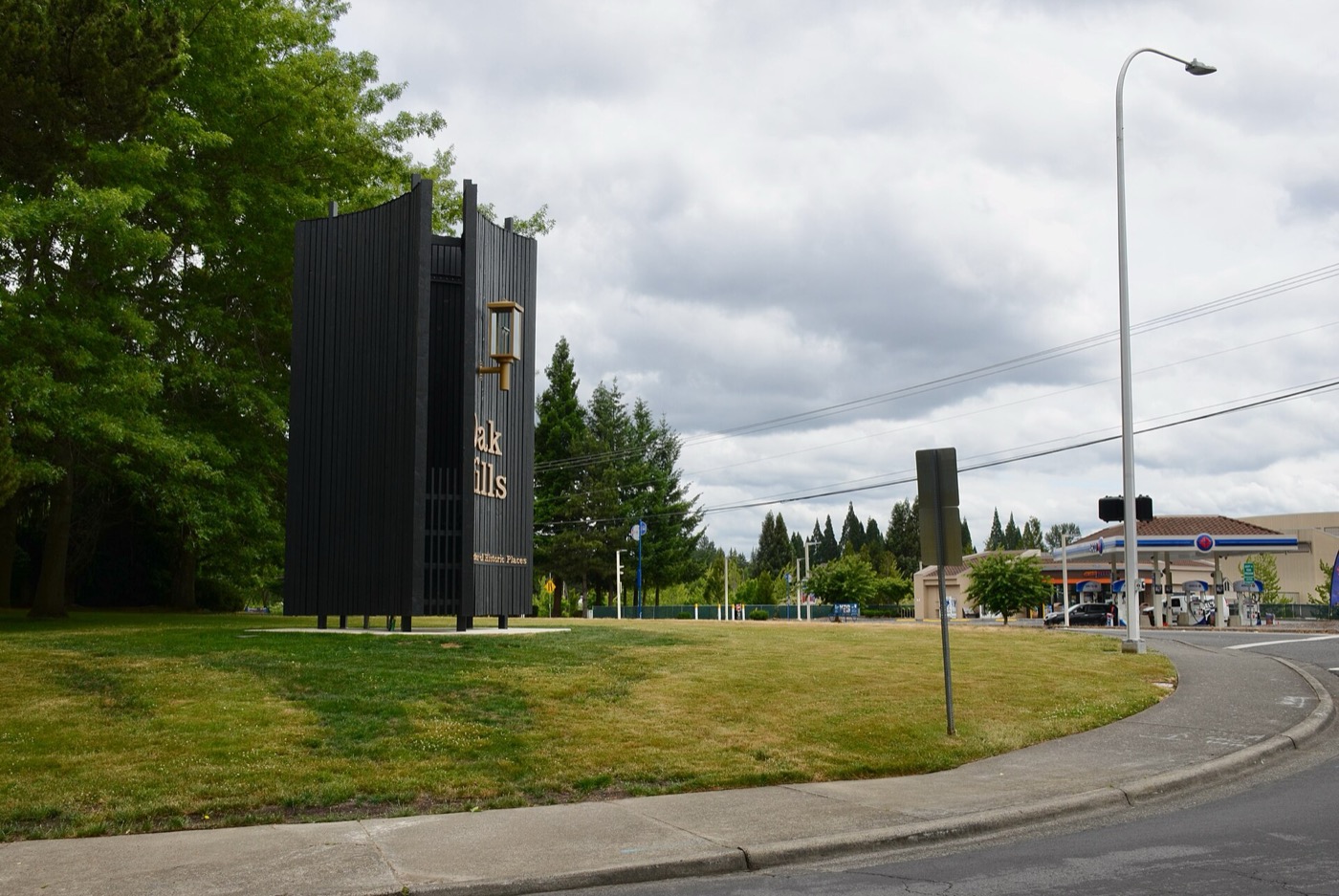 Restored brick Oak Hills neighborhood entrance sign beside Cornell Road