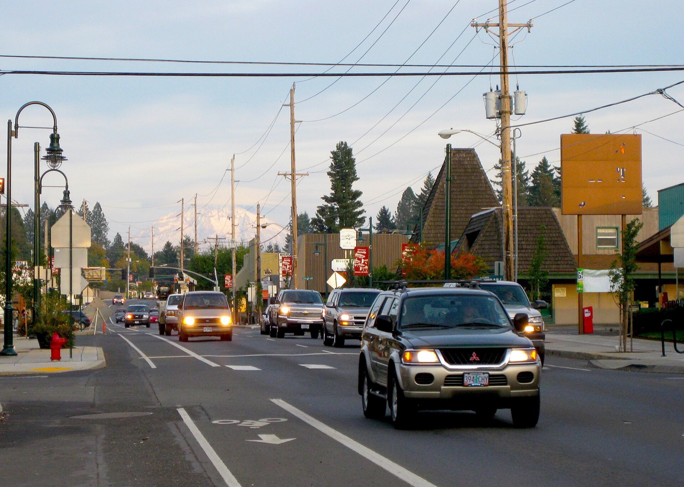 Traffic on the main street through Sandy with Mount Hood visible in the distance