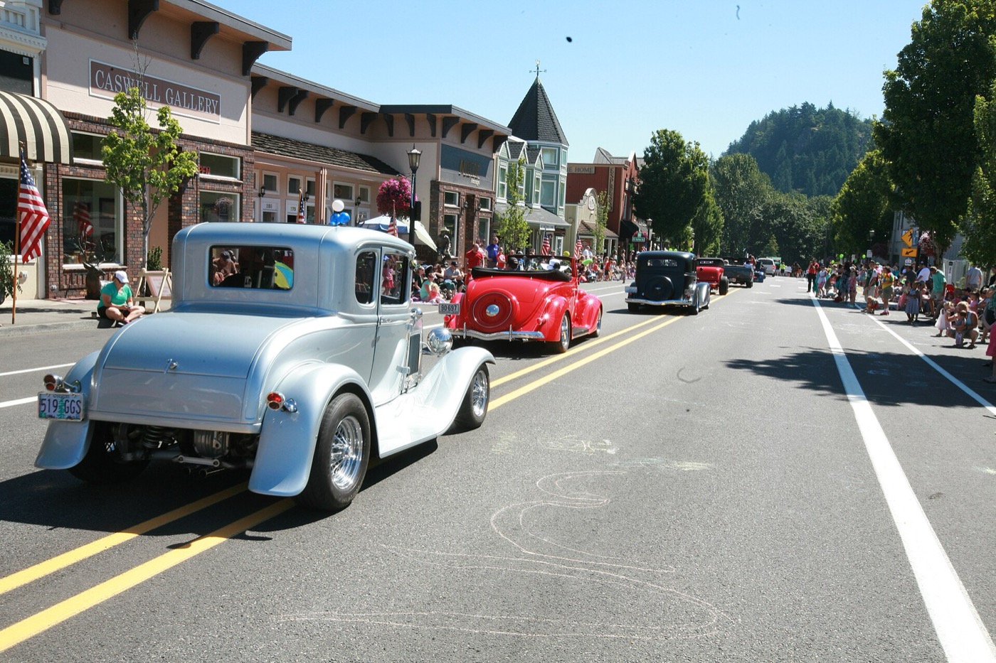 Classic cars driving along the historic main street of downtown Troutdale
