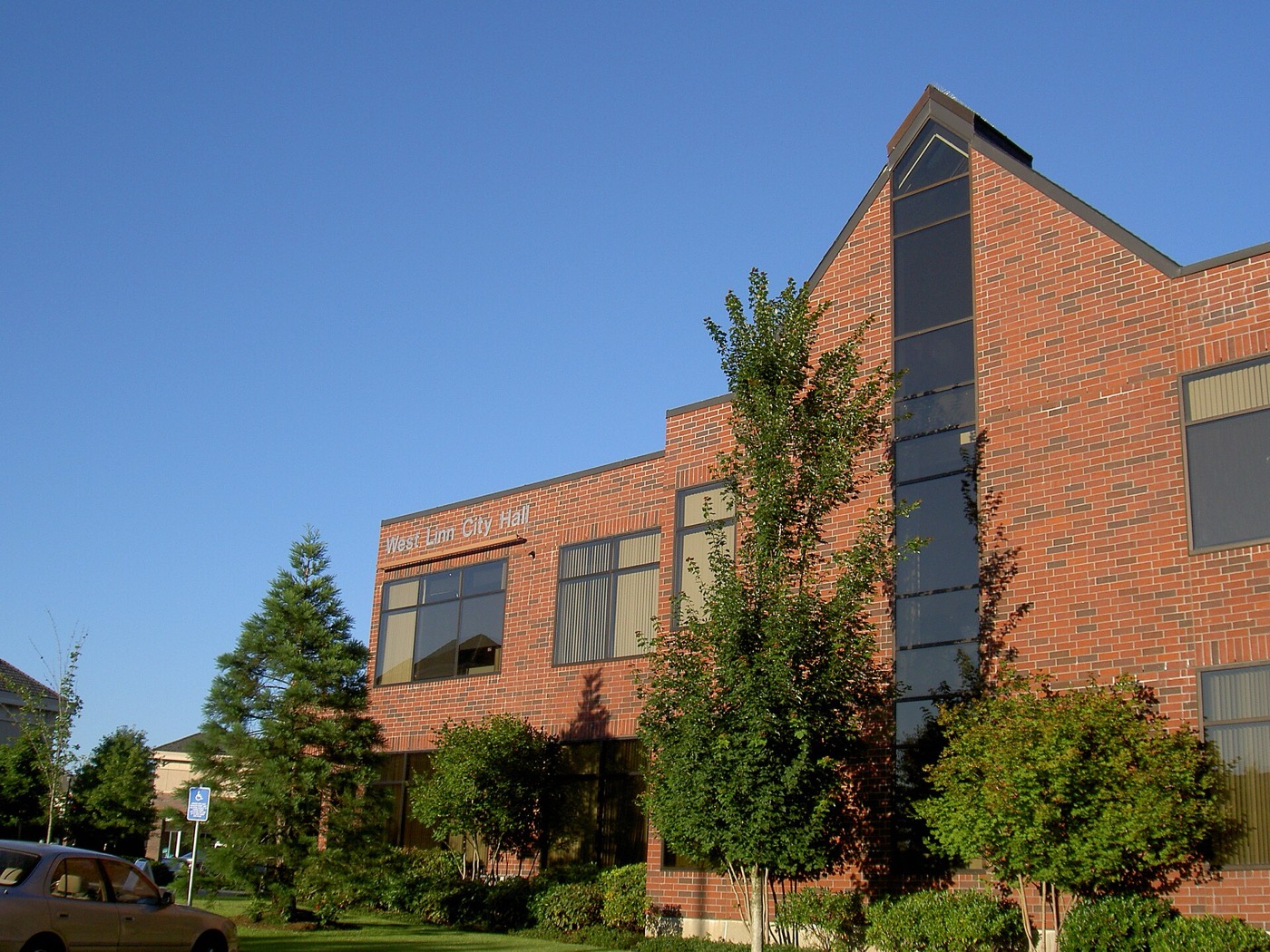 Brick West Linn City Hall building with trees and landscaping
