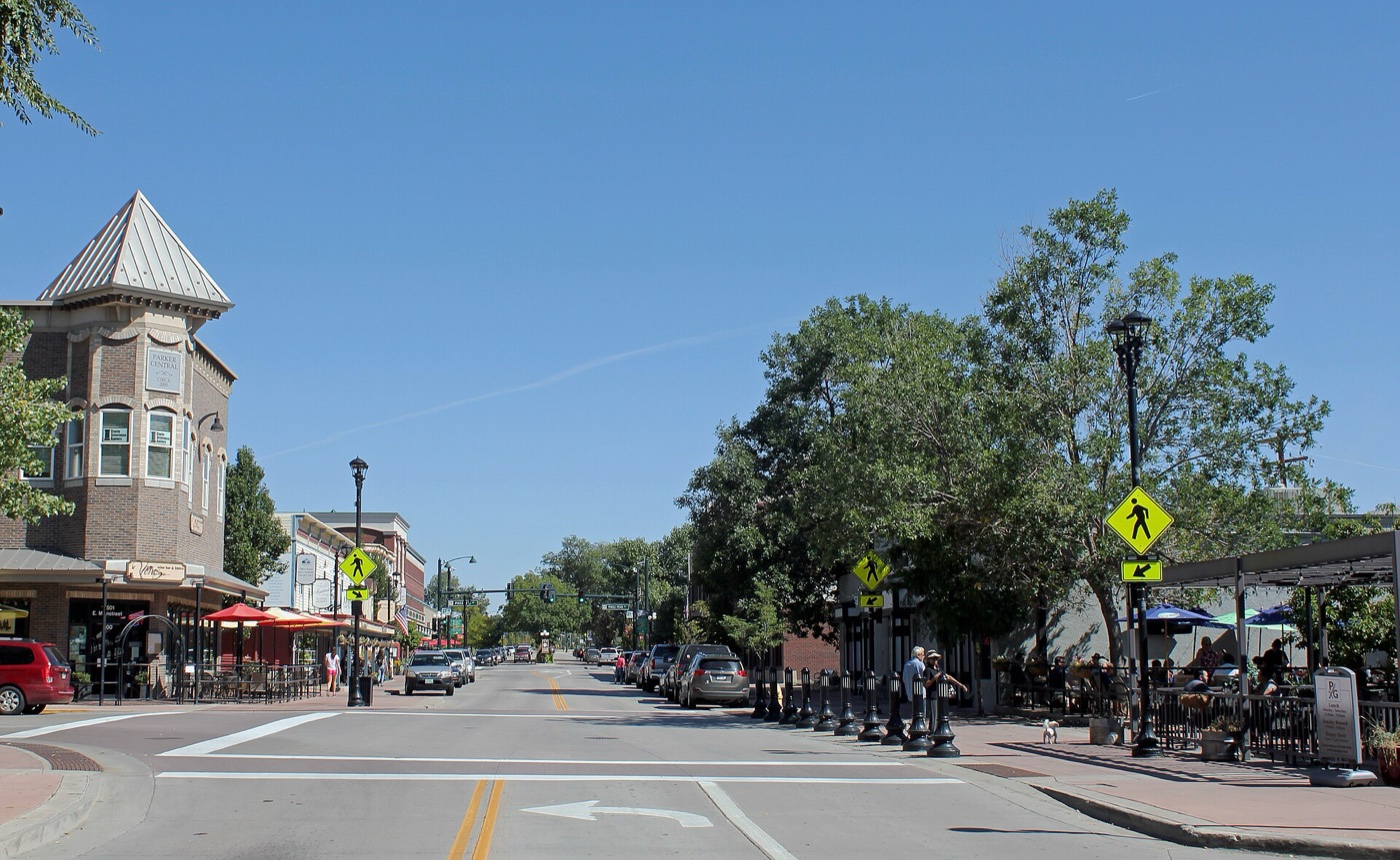 Tree-lined Mainstreet in downtown Parker with shops and a turreted corner building