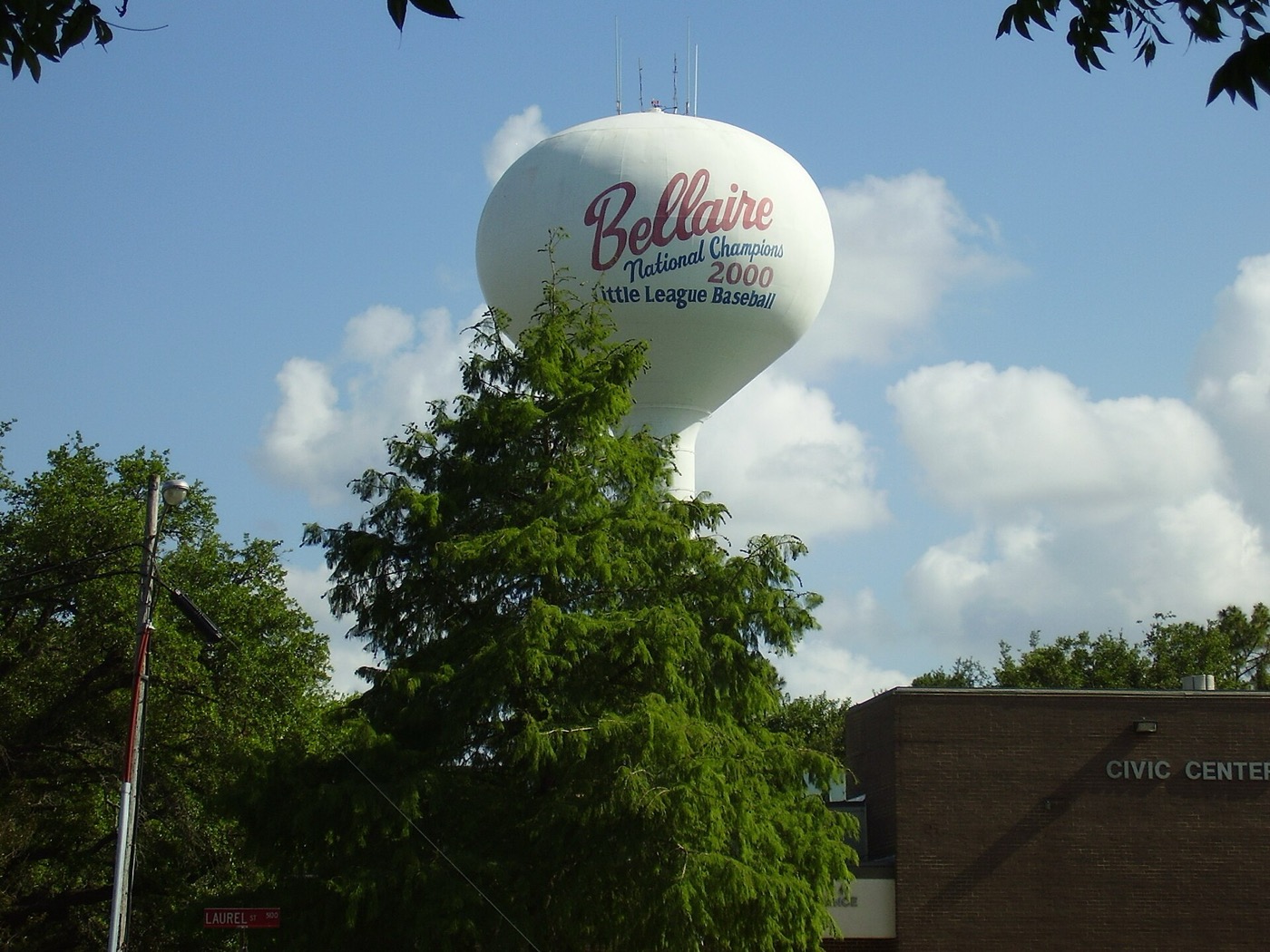 White Bellaire water tower above trees next to the civic center