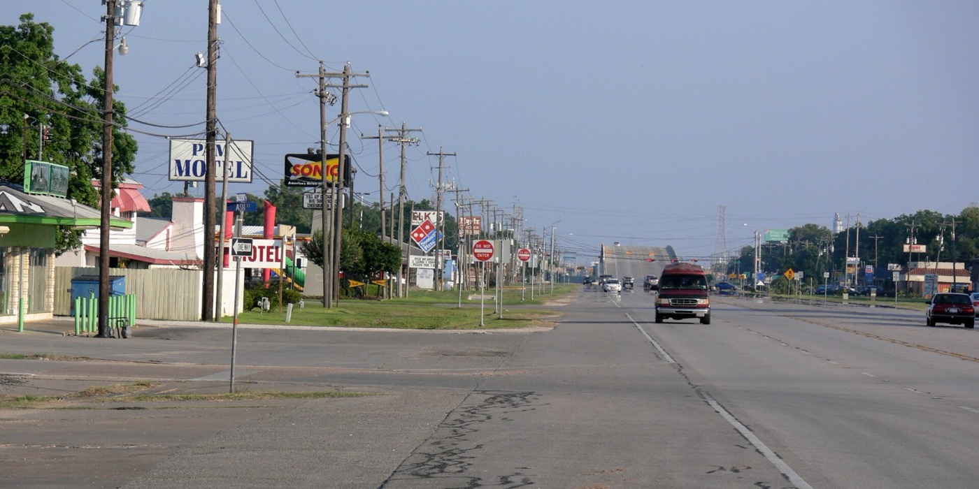 Business Highway 288 through Clute, Texas, lined with shops and signs