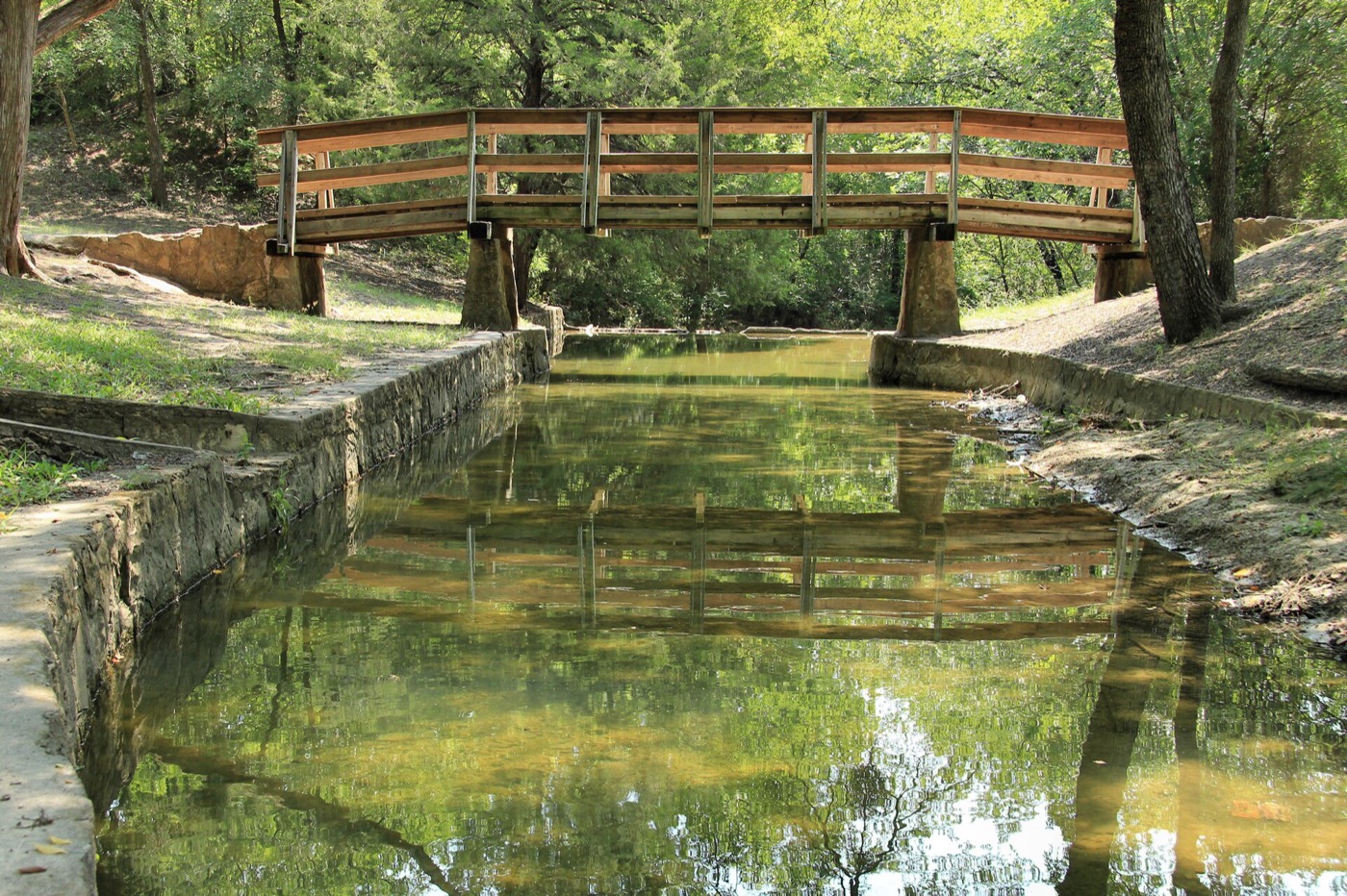Stone-lined creek channel and footbridge in Grapevine Springs Preserve, Coppell