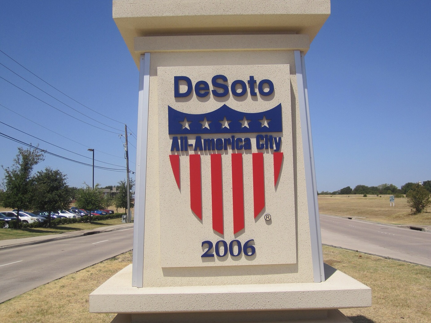 Stone pillar sign reading DeSoto All-America City 2006 beside a road