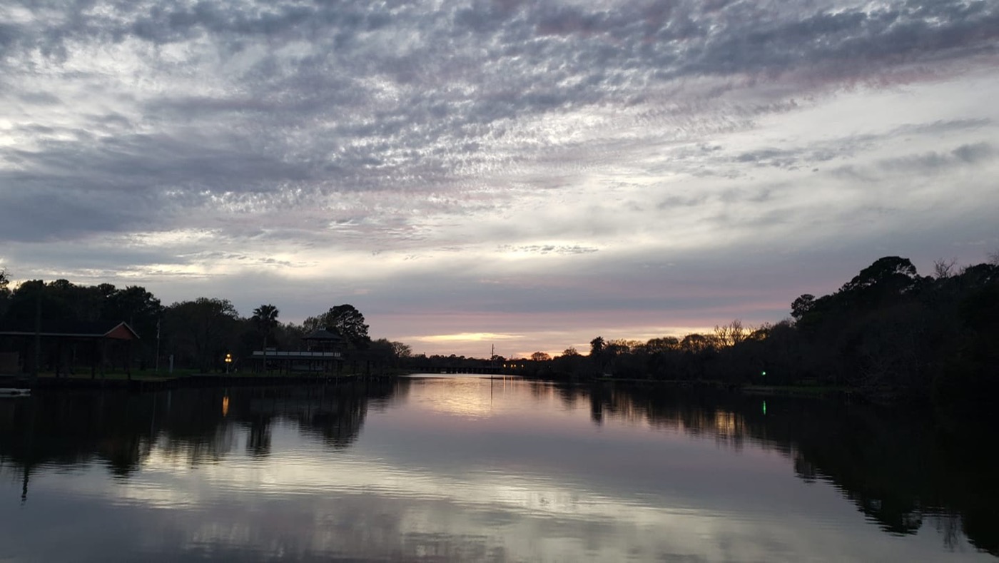 Dickinson Bayou at sunset with trees along the bank