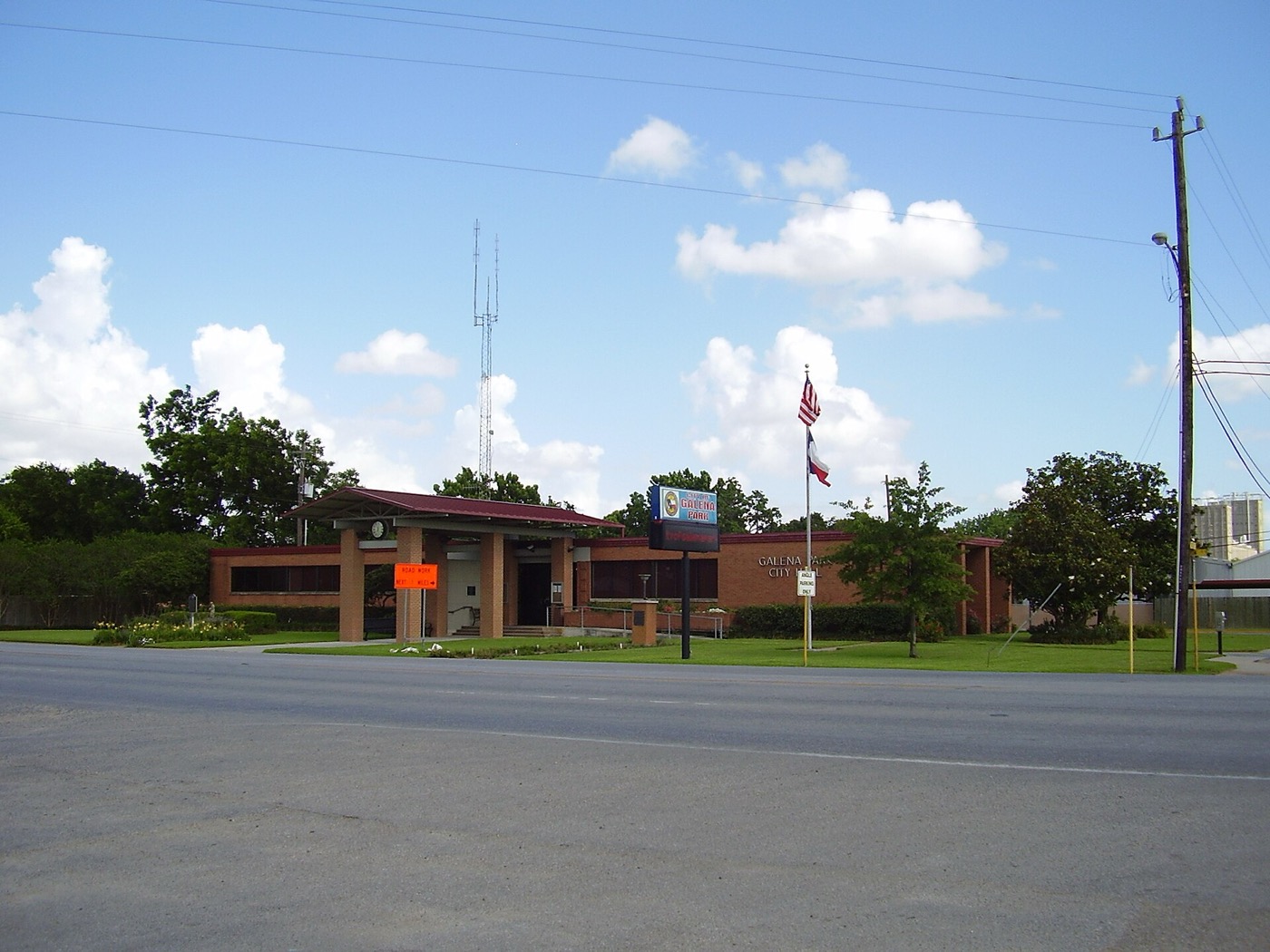 Single-story brick Galena Park City Hall with a flagpole, seen across the street