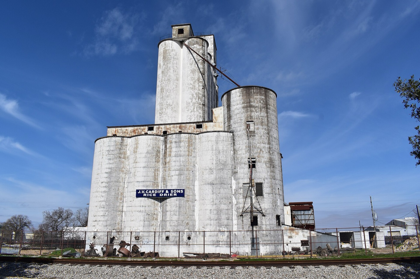Tall rice dryer silo structure in Katy, Texas under a blue sky
