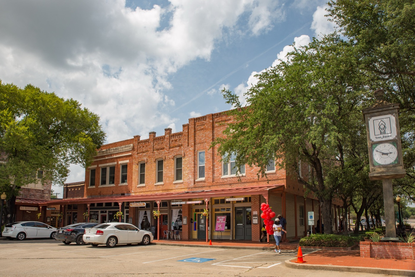 Two-story red brick commercial building and street clock on the historic town square in Lancaster, Texas