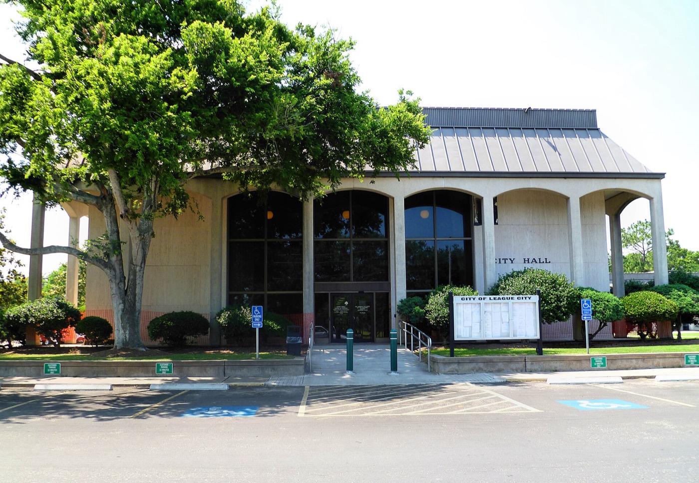 League City City Hall building with flagpoles and landscaping in League City, Texas