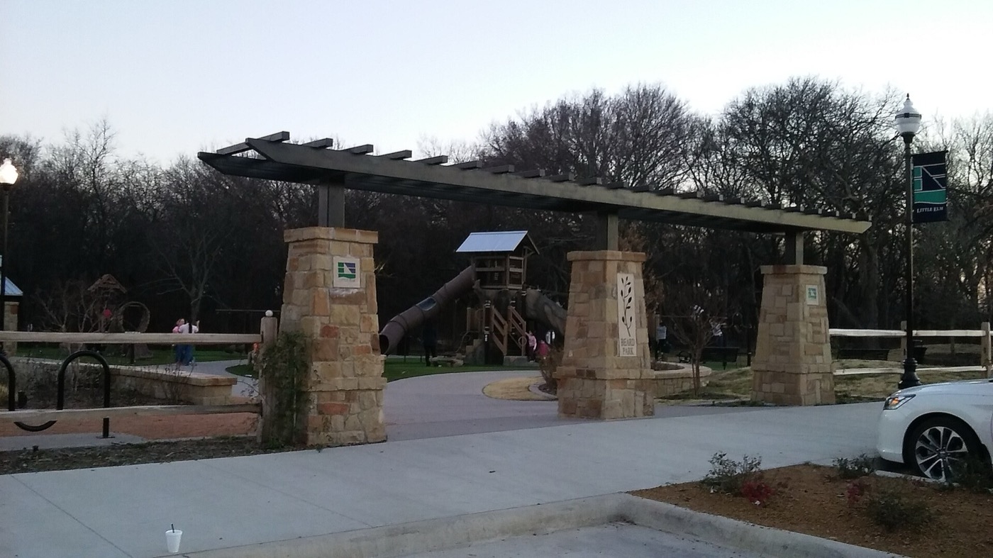 Stone-pillared pergola entrance to Beard Park in Little Elm, Texas, at dusk
