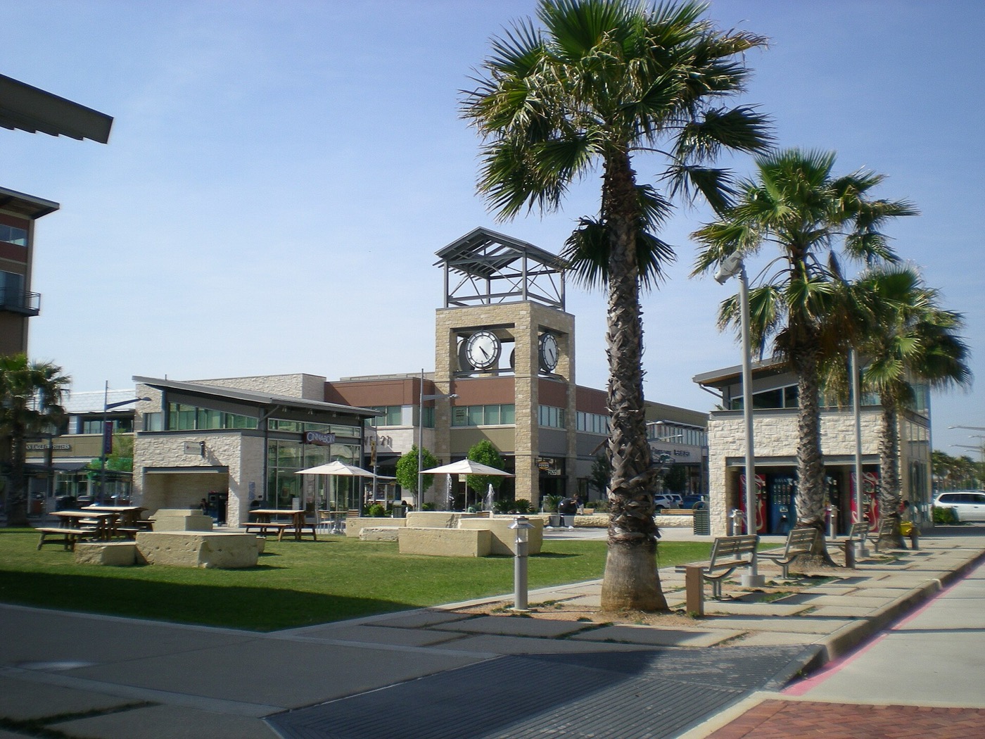 Clock tower, palm trees and storefronts at the Pearland Town Center shopping center