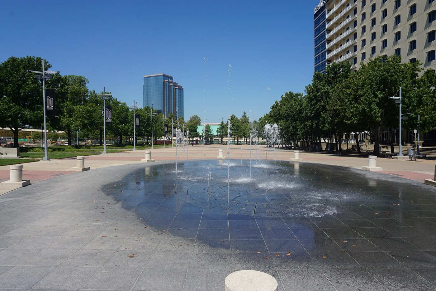 Open plaza with a shallow fountain and office towers in Richardson, Texas