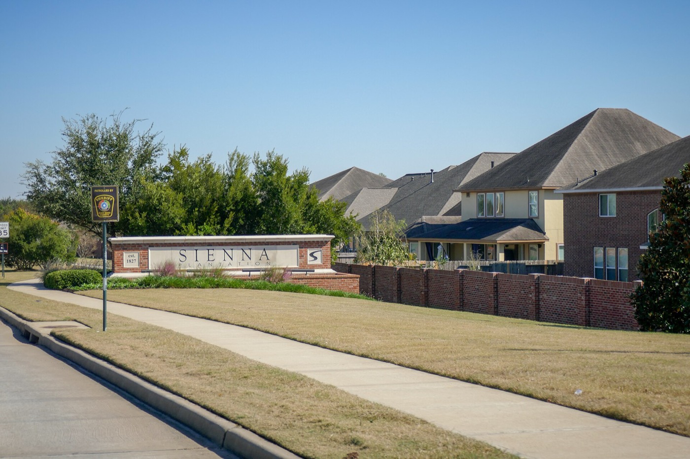 Sienna community entrance sign with brick homes behind it