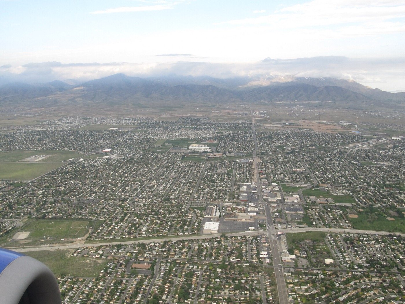 Aerial view of Kearns neighborhoods with the Utah Olympic Oval near the center and the Oquirrh Mountains beyond