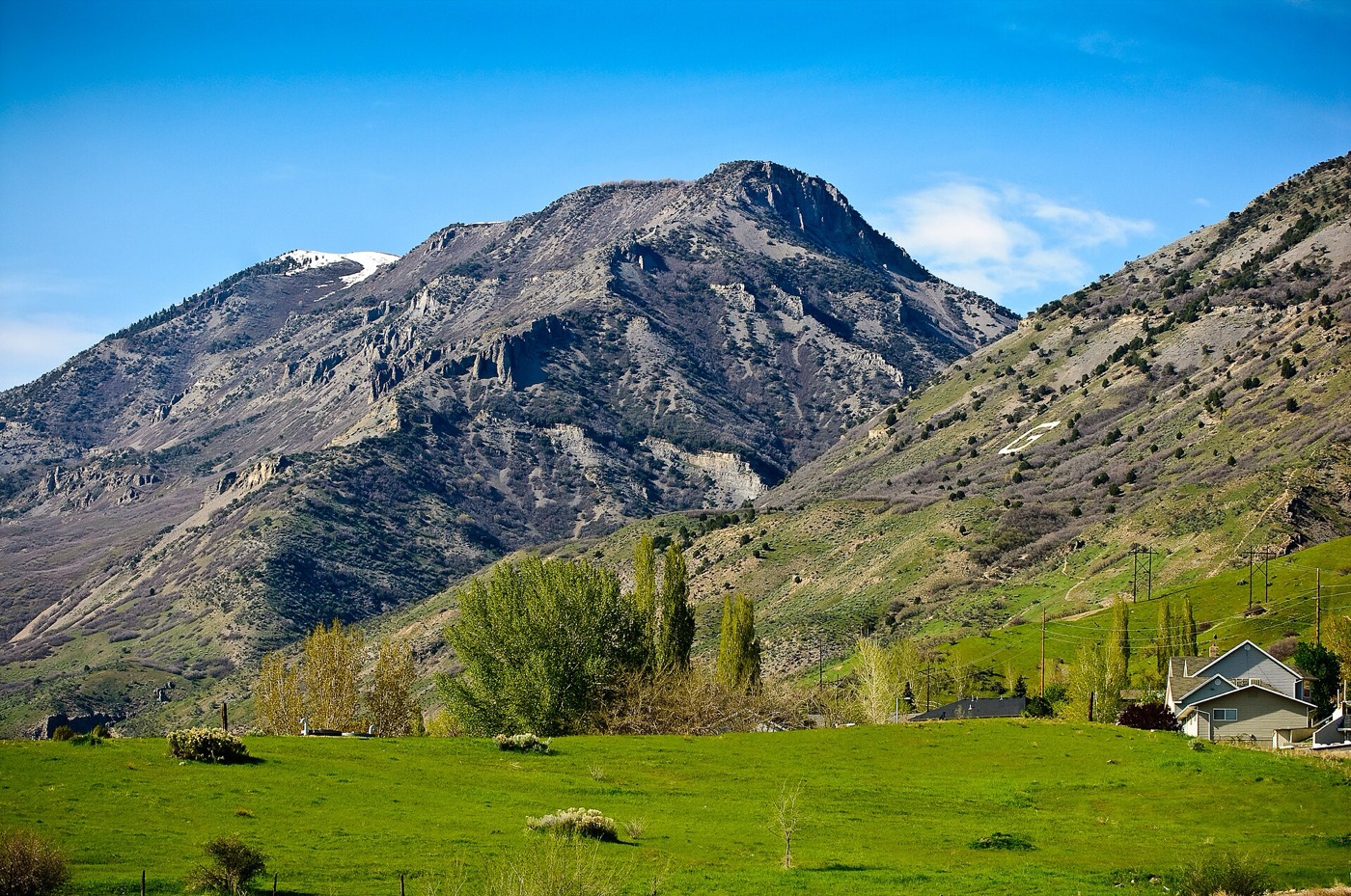Green fields and a house below the Wasatch Mountains in Lindon, Utah