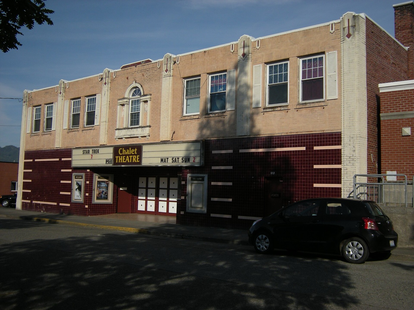 The brick and stucco Chalet Theatre building with its marquee on a downtown Enumclaw street