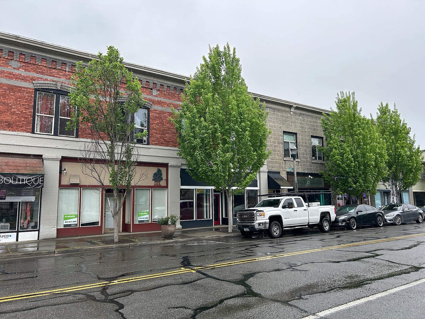 Brick and stone storefront buildings with street trees along 1st Avenue South in downtown Kent, Washington