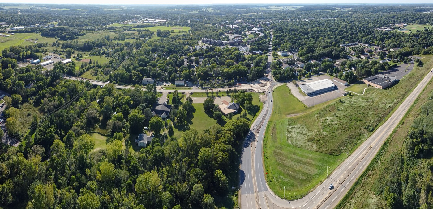 Aerial view of River Falls neighborhoods, trees and a highway interchange